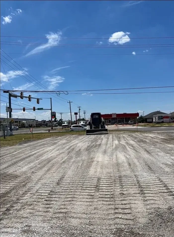 Track loader packing a commercial gravel pad