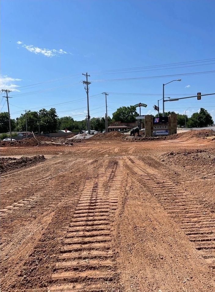 Rough-graded commercial lot at a busy intersection